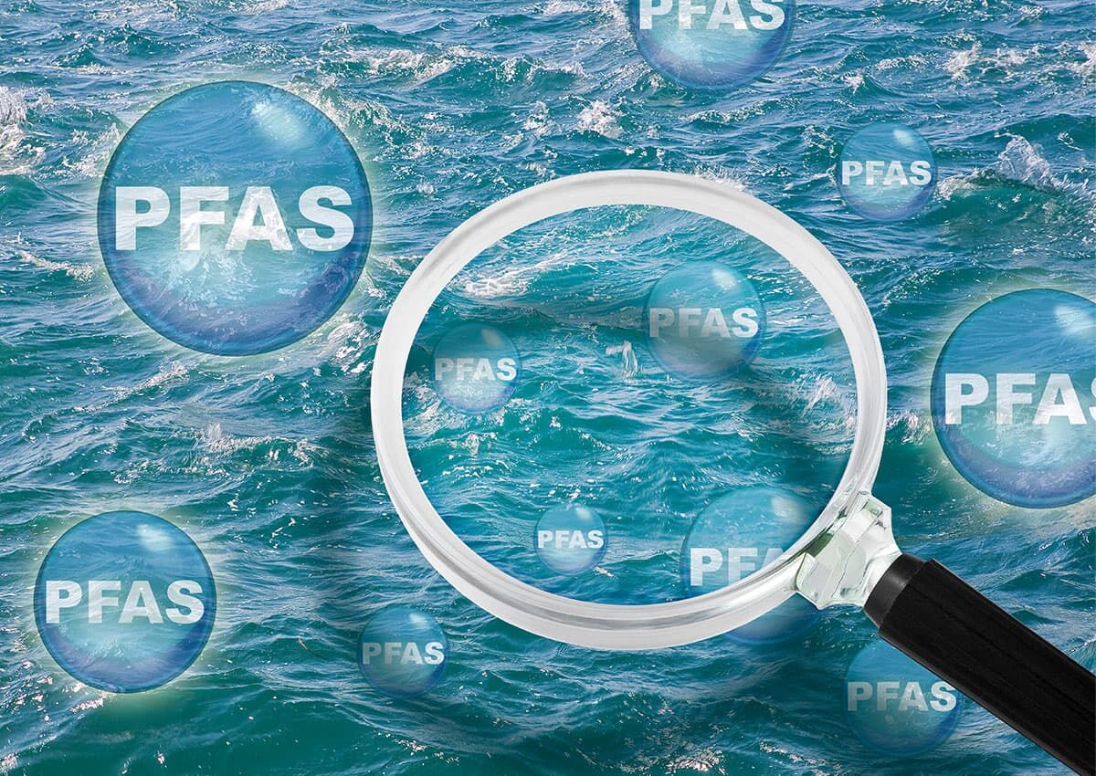Symbolische Darstellung von PFAS in Wasser mit Lupe